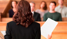 Woman at podium in front of listeners