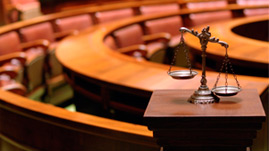 Scales of justice on a pedestal in a courtroom
